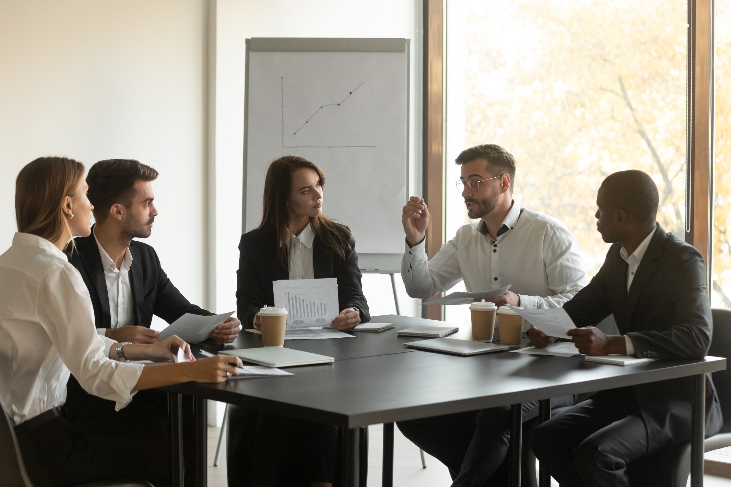 Mixed race young business employees team listening to leader.